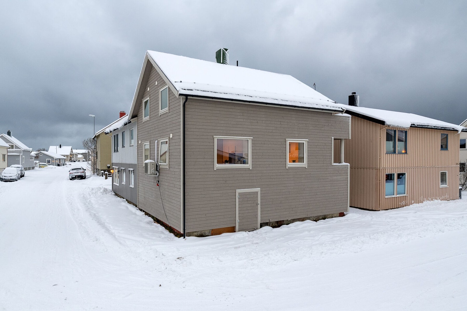 Fasade og uteområde. Det meste av tomtearealet er adkomstvei, parkeringsplass og noe grønt areal. Galleribilde