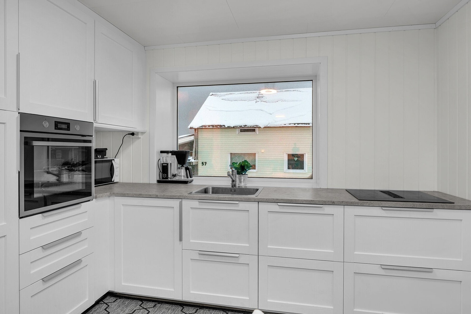 Klassisk, pen kjøkkeninnredning med lyse profilerte fronter. Galleribilde