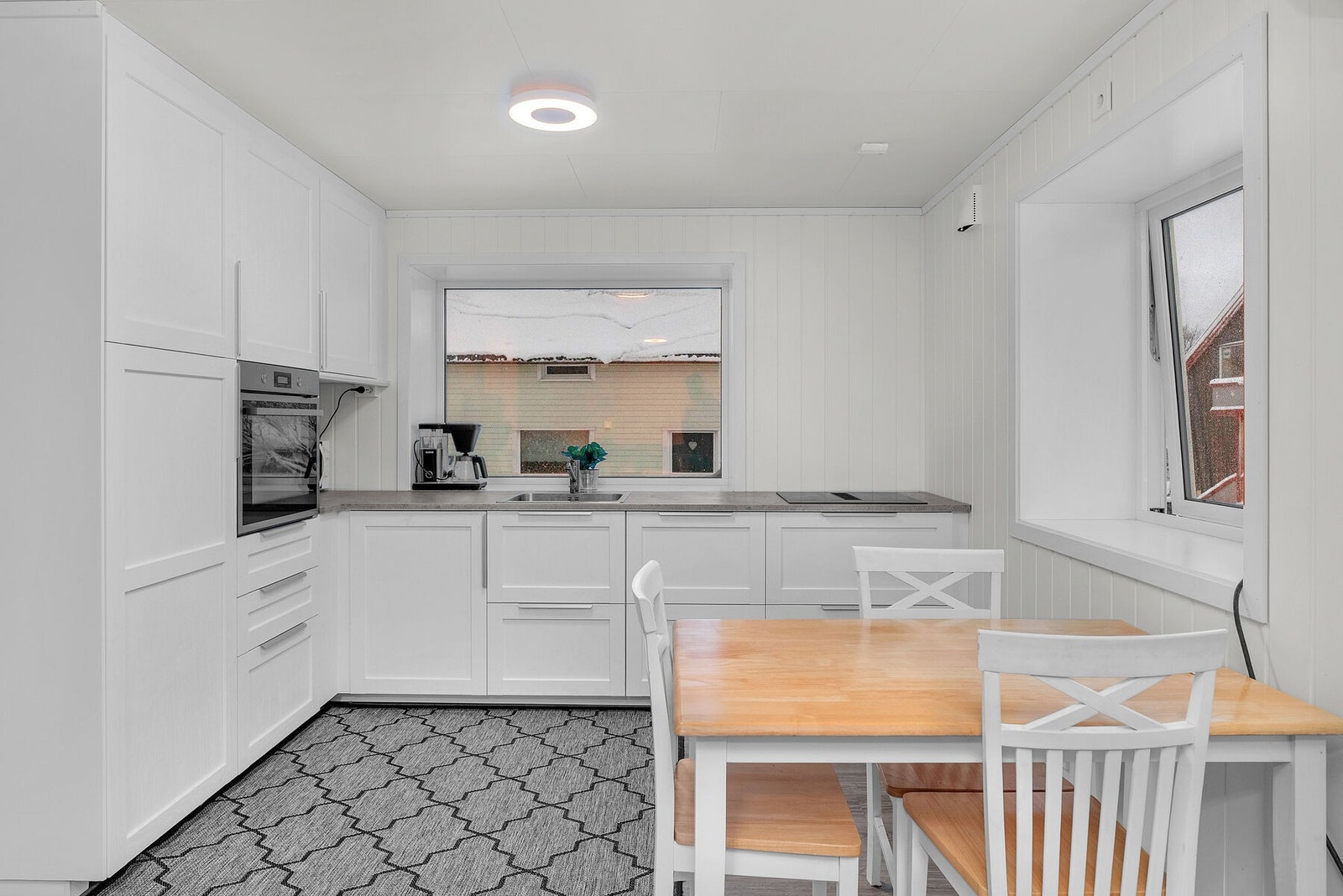 Lyst og klassisk kjøkken med integrerte hvitevarer. Galleribilde