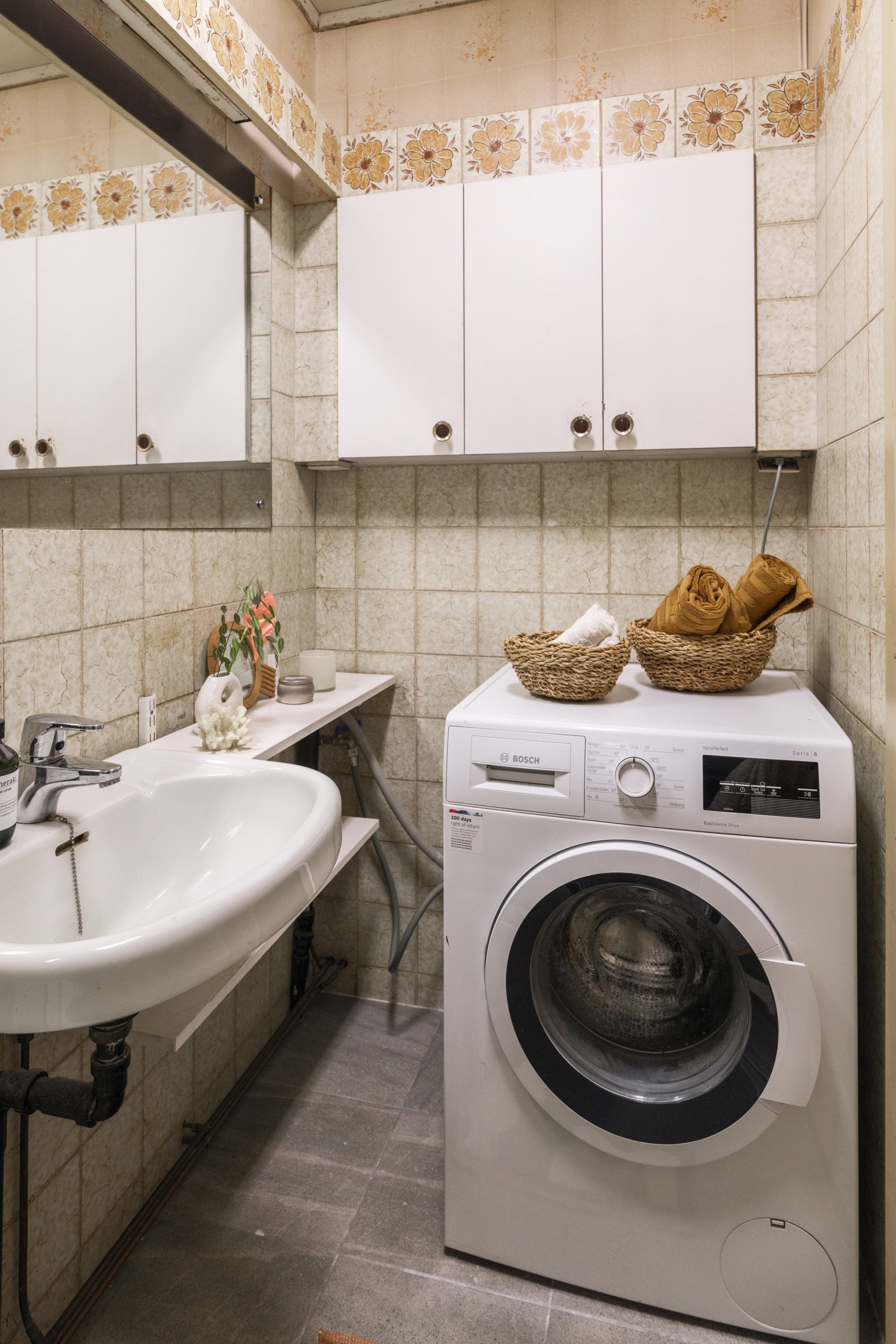 Baderommet er uttyrt med vegghengt servant med speil over, vegghengte skap, dusjkabinett og opplegg for vaskemaskin. Galleribilde