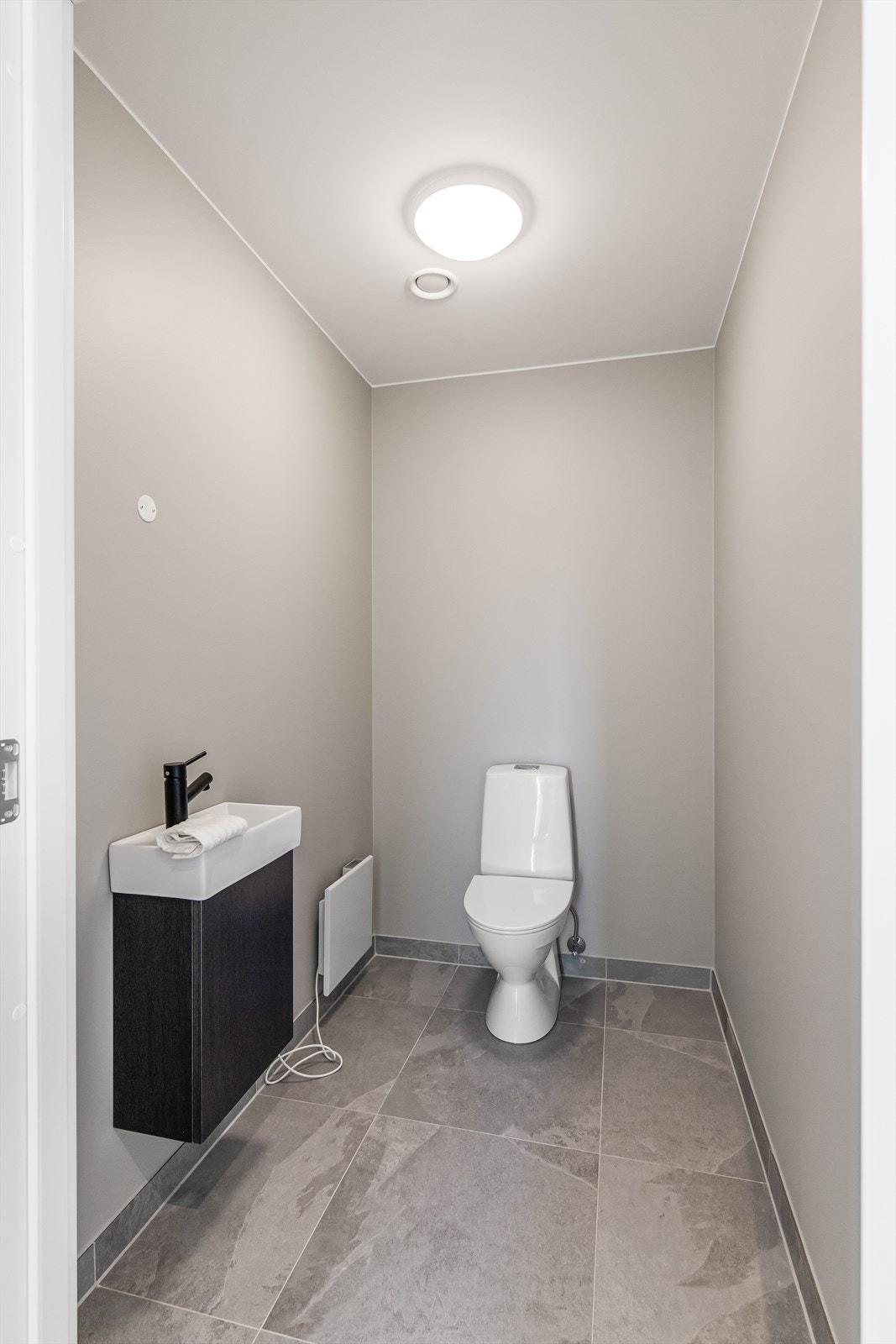 Gjestetoalett med servant i skap og toalett Galleribilde