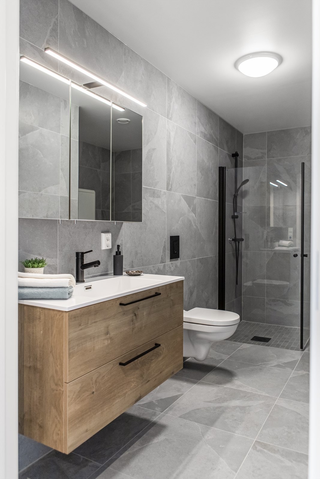 Badet er innredet med tidløse flisevalg på vegger og gulv Galleribilde