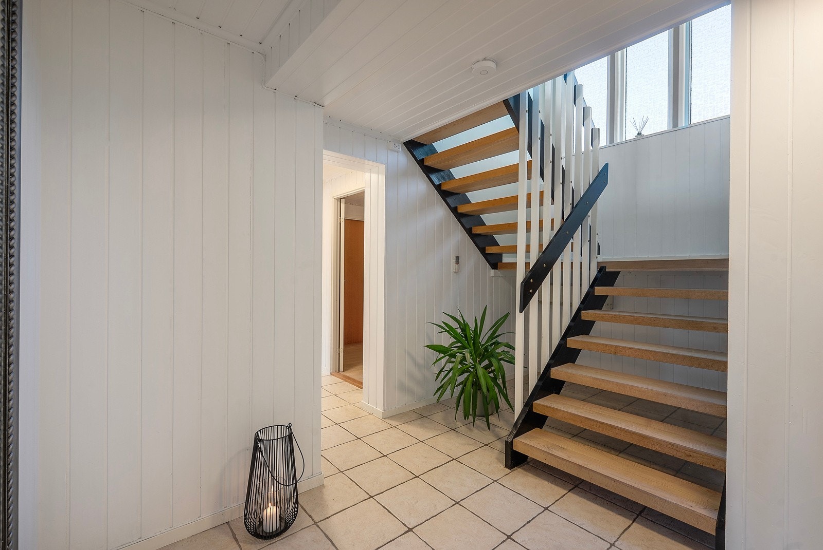 Romslig hall med trapp til 2.etg. Galleribilde