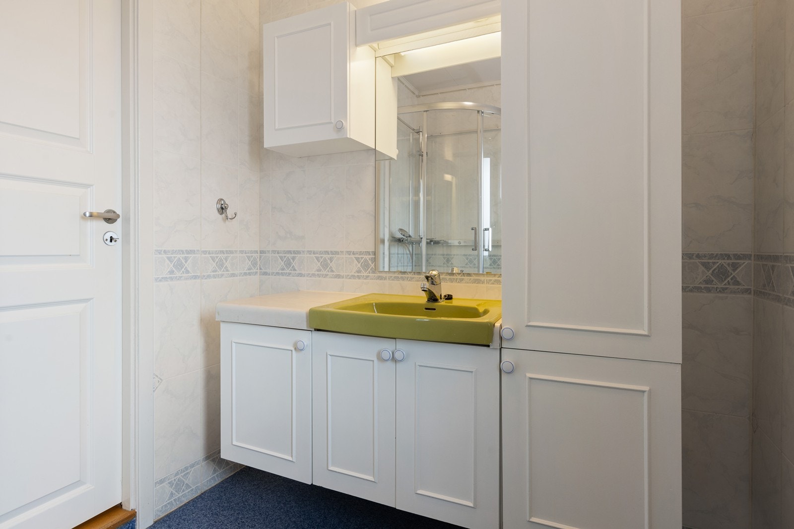 Badet er innnredet med dusjkabinett, servantinnredning med underskap og speil. Galleribilde