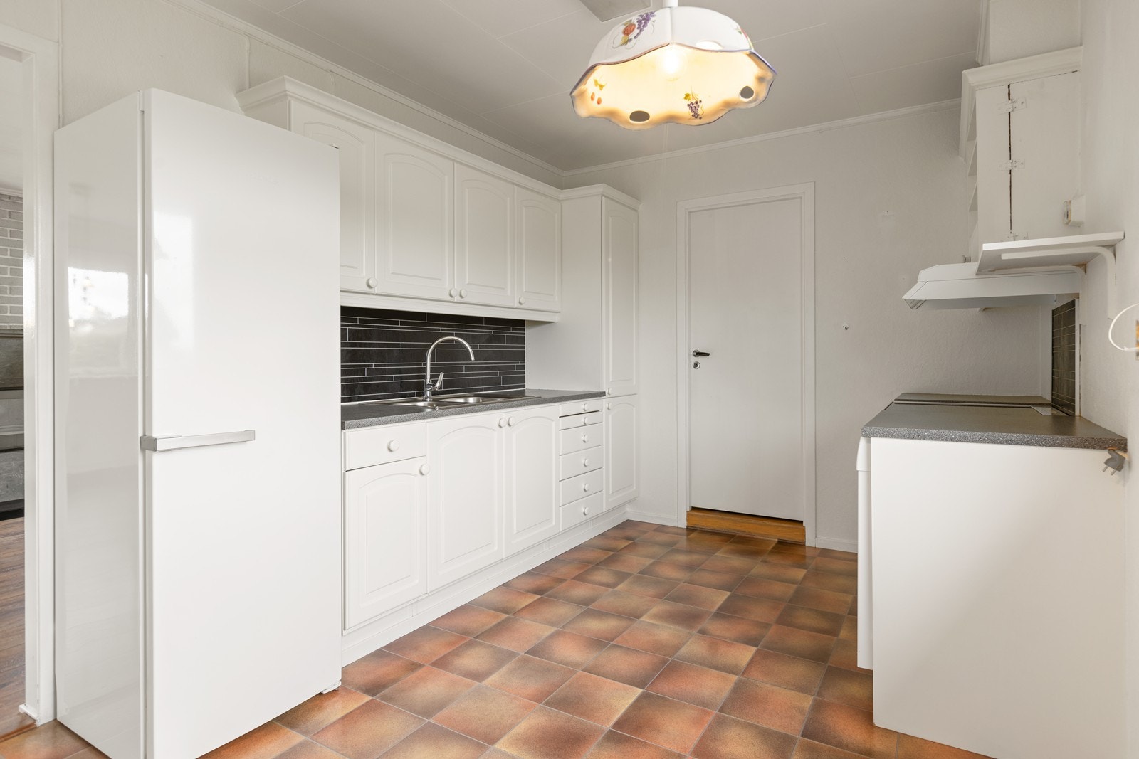 Lyst kjøkken som har innredning med profilerte fronter og benkeplater av laminat. Galleribilde