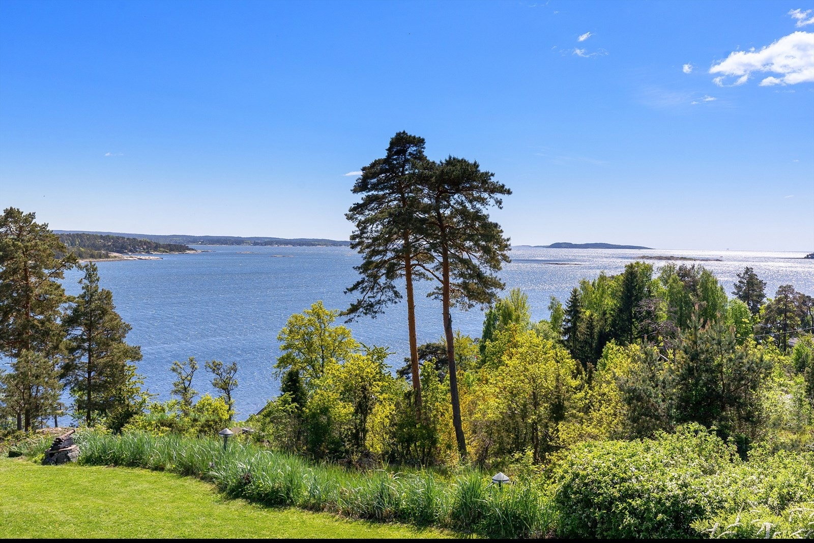 Tomten ligger fint i terrenget, med utsikt mot fjorden, grønne omgivelser og en beliggenhet som fremhever både ro og kvalitet. Galleribilde
