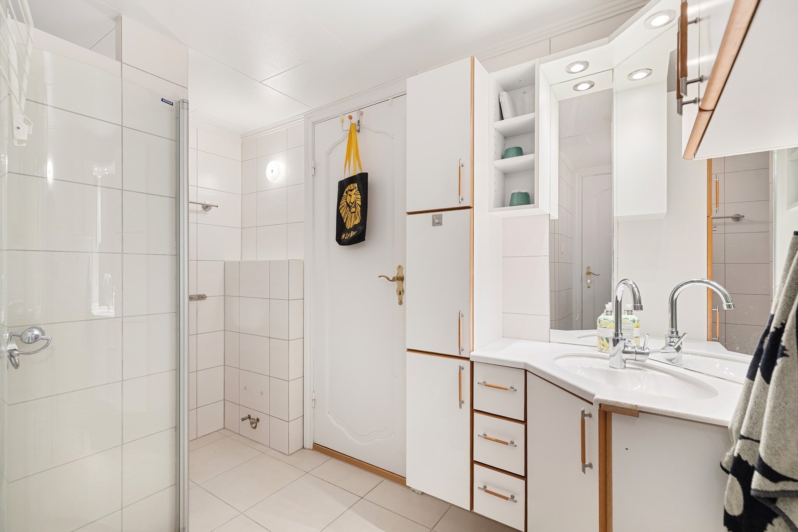 Det andre badet er fra rundt 2012 og har flislagte overflater, innredning med nedfelt servant, dusjhjørne og opplegg for vaskemaskin. Galleribilde