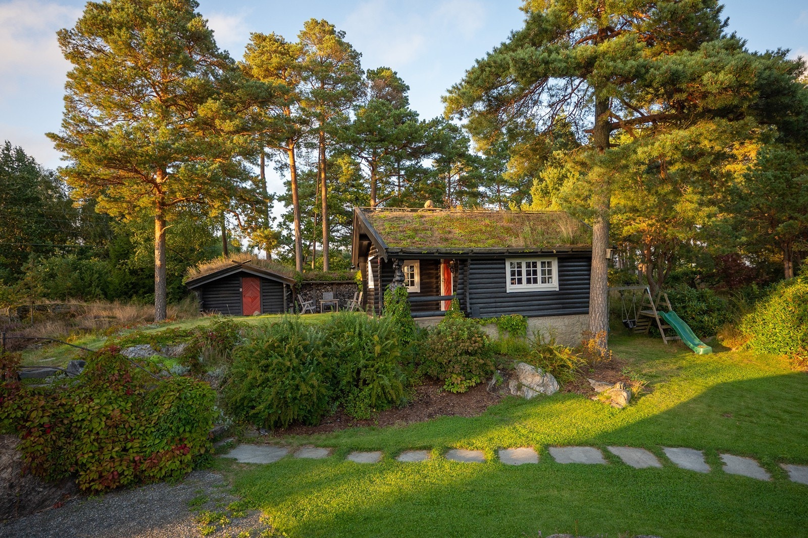 Her får du en romslig hovedbolig kombinert med en skjermet gjestebolig, omgitt av store og opparbeidede uteområder. Galleribilde