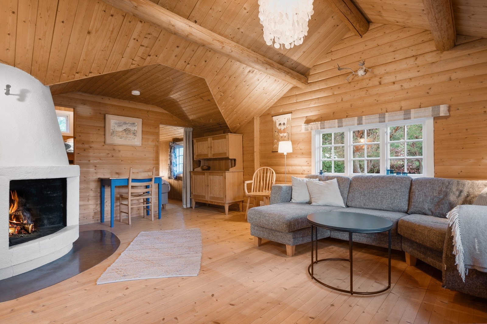 Stuen har en lun atmosfære med peis og gjennomgående bruk av treverk. Galleribilde