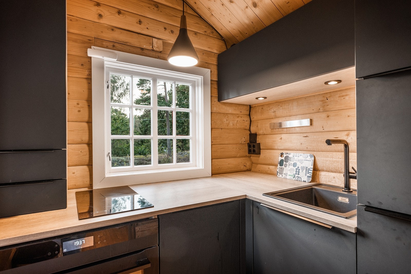 Schmidt kjøkken fra Øvereng Interiør var nytt i 2022, og ligger i eget rom i tilknytning til stuen. Innredningen har sorte, slette fronter og laminat benkeplate med nedfelt kum. Galleribilde