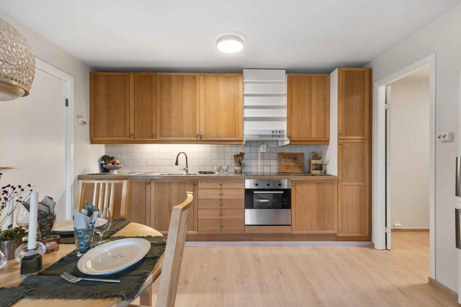 Pen Ikea-kjøkkeninnredning fra 2010 med profilerte fronter og laminat benkeplate Galleribilde