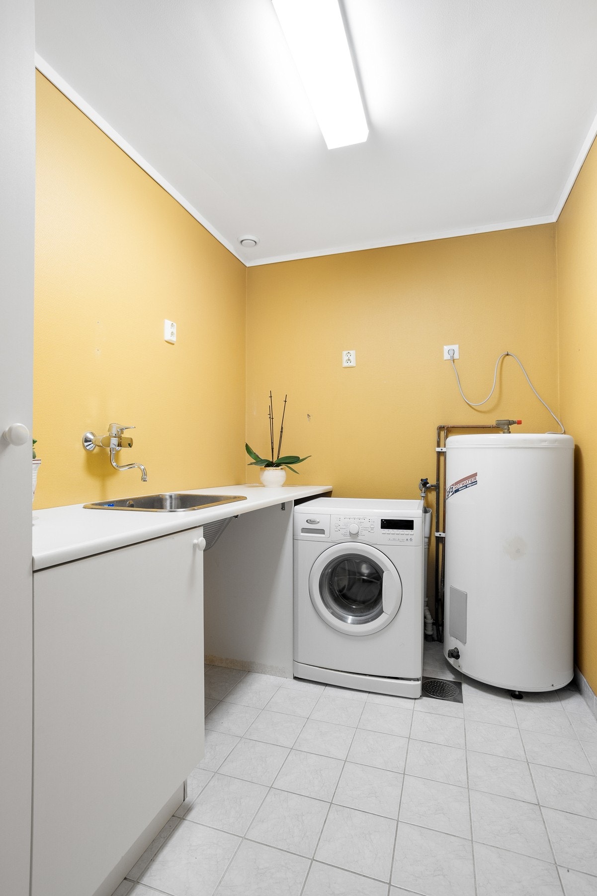 Vaskerom med god plass til oppbevaring og opplegg til vaskemaskin Galleribilde