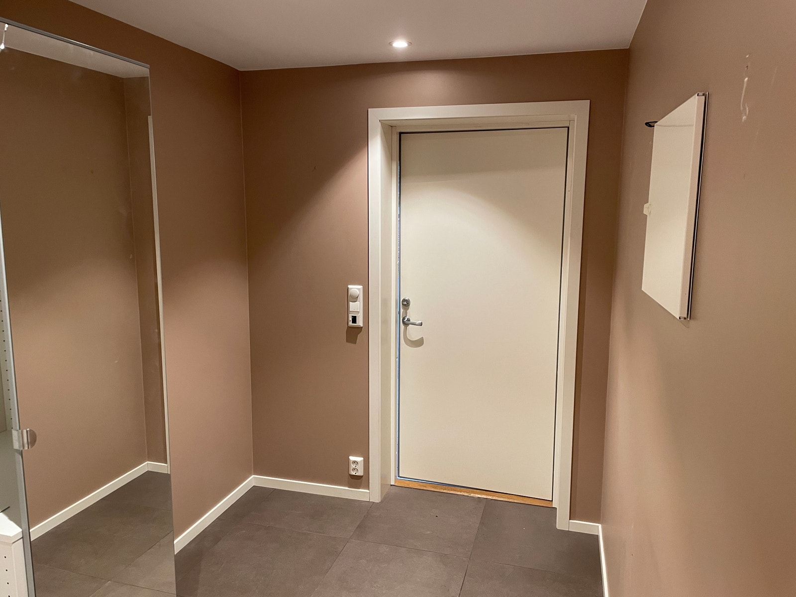 Entre med ytterdør på bilde, fliser på gulv og varmekabler, romslig plass til klær og sko. Det er også et skap i hjørne for klær. Galleribilde