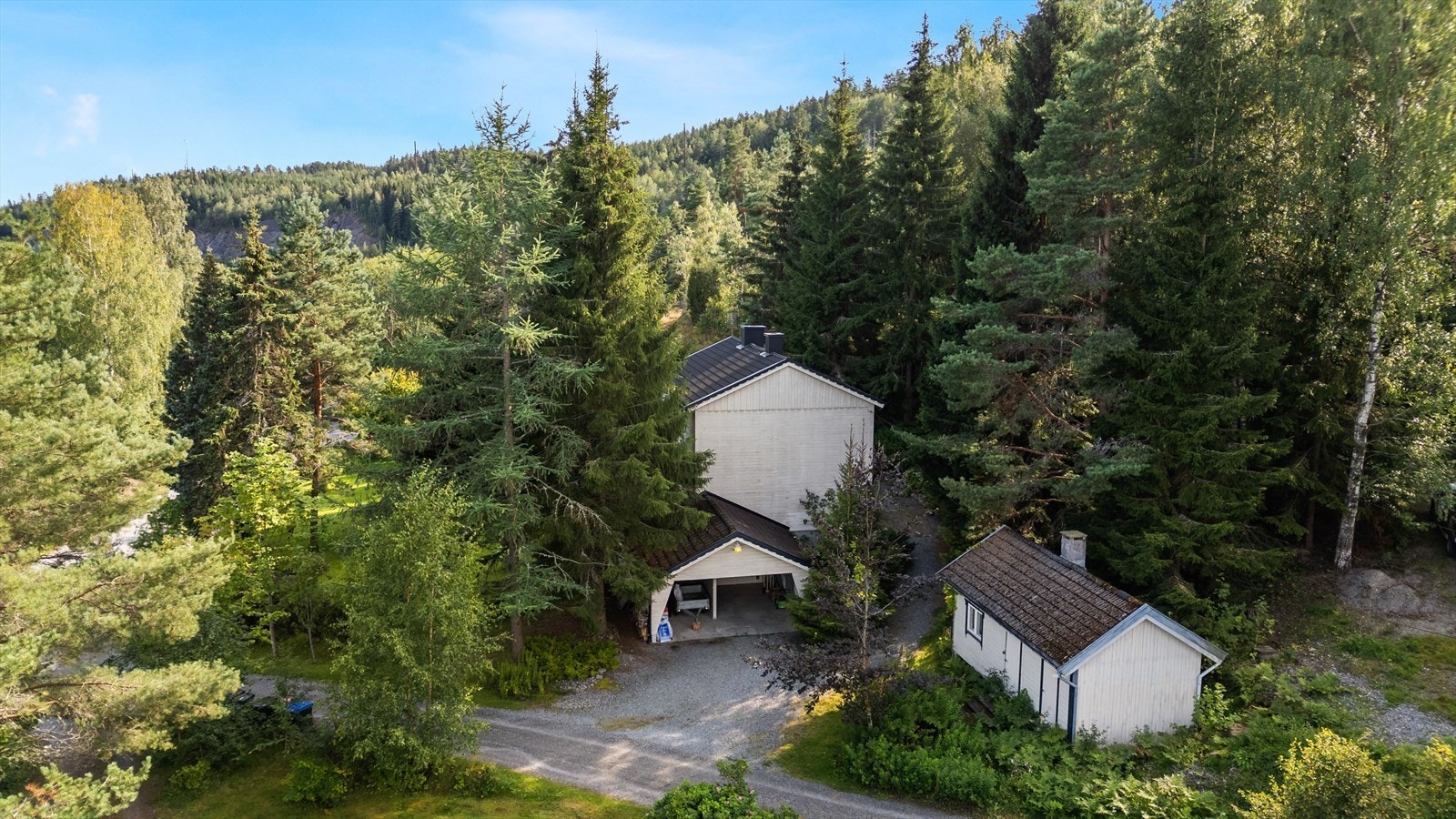 Enebolig består også av en frittstående carport og et uthus/anneks. Galleribilde
