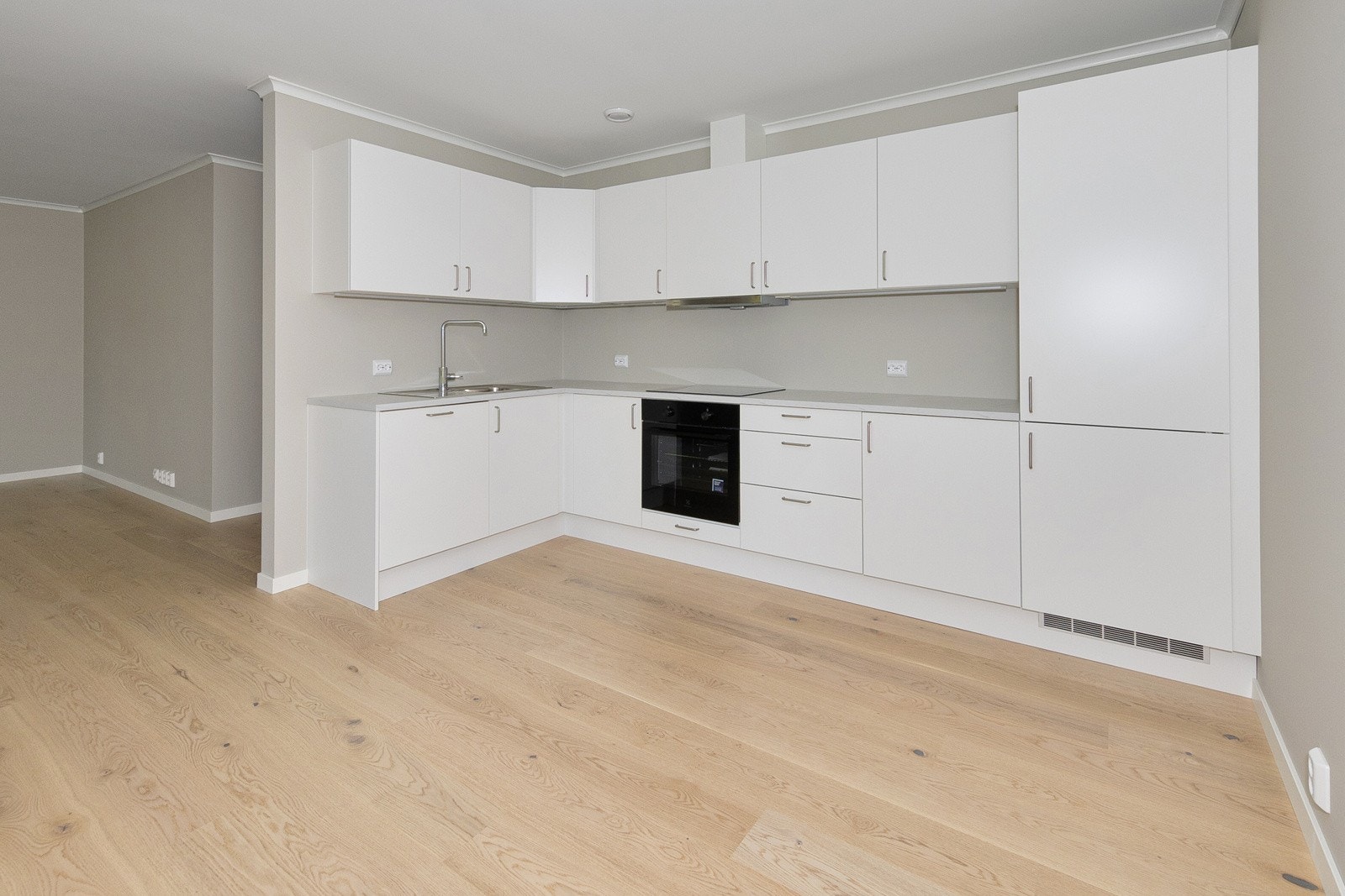 Kjøkkenet er lyst og minimalistisk med et funksjonelt design, preget av enkle linjer og rene flater. Galleribilde