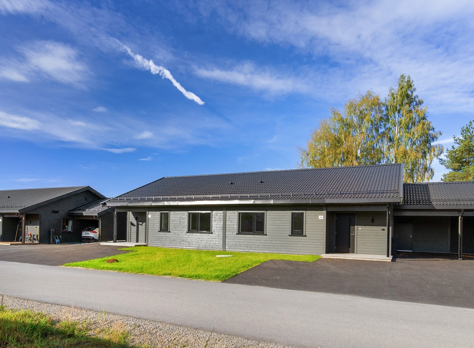 Det er også en gressplen i fromt hvor noen har valgt å asfaltere noe mer av denne. Galleribilde