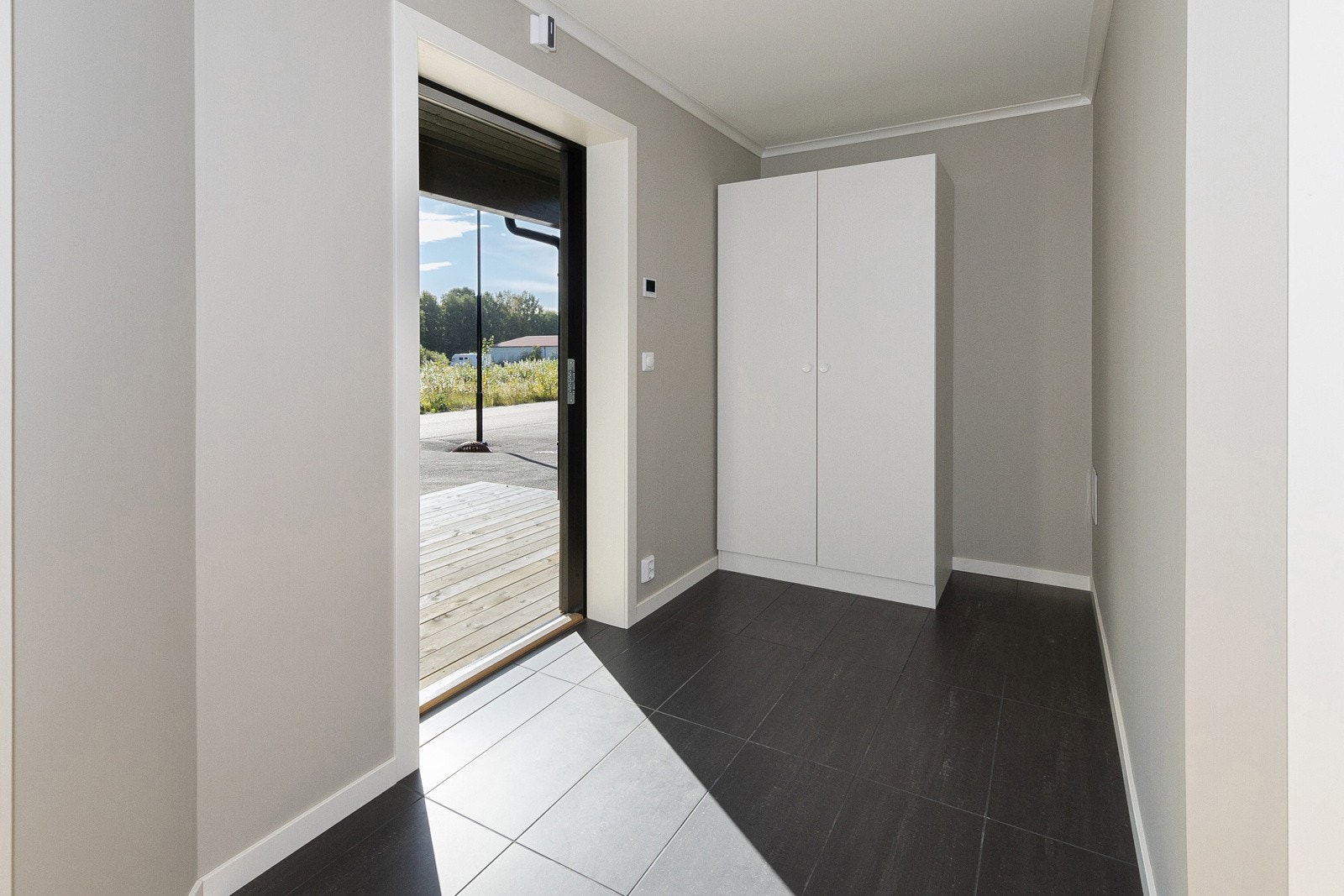 Romslig gang med flis og vannbåren varme i gulv. Praktisk overbygg på utsiden slik at inngangsdøren er skjermet. God plass til garderobeskap. Galleribilde