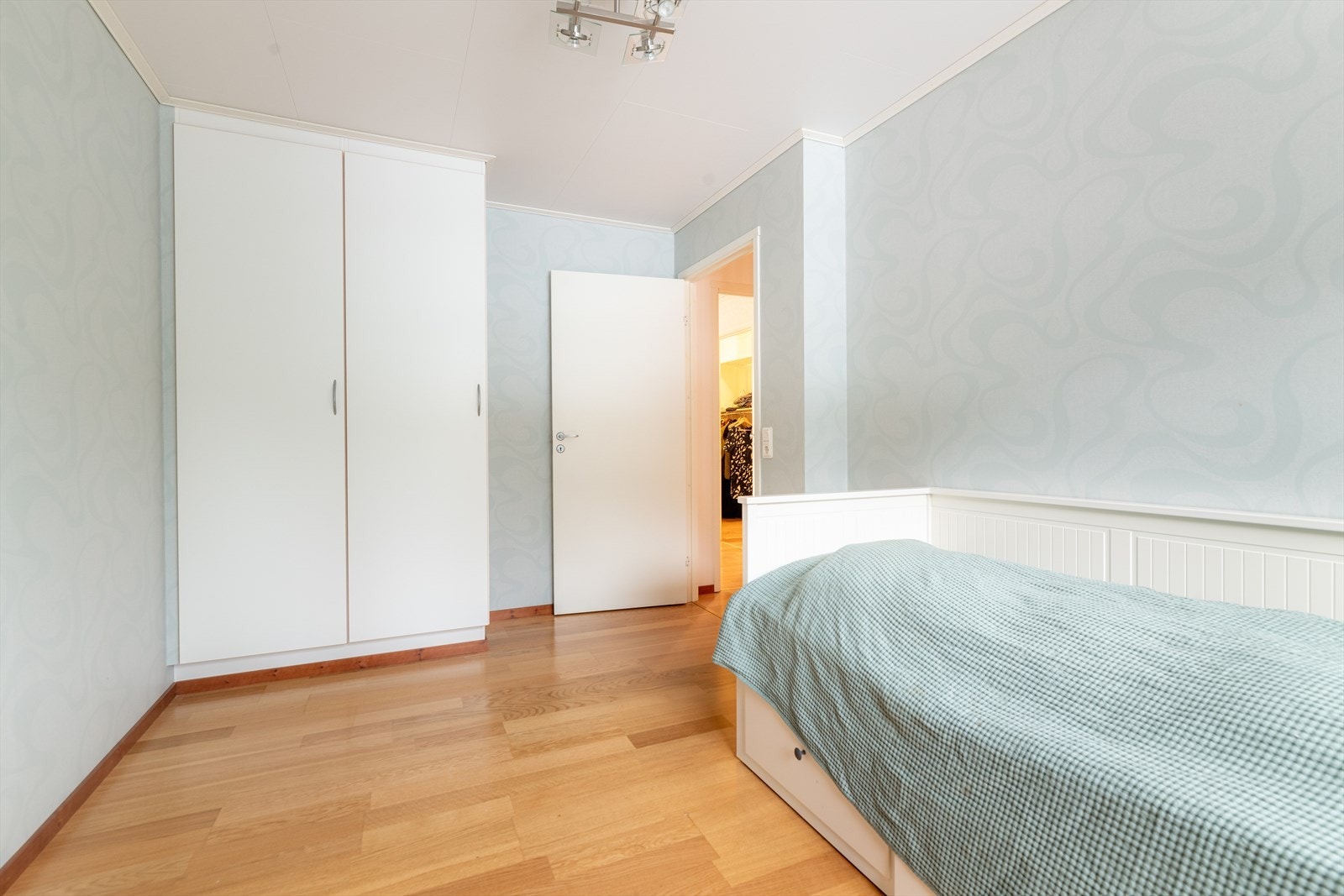 Praktiske, plassbygde garderobeskap for klesoppbevaring. Overflater på soverommene består av laminat på gulv og tapet på vegger. Galleribilde