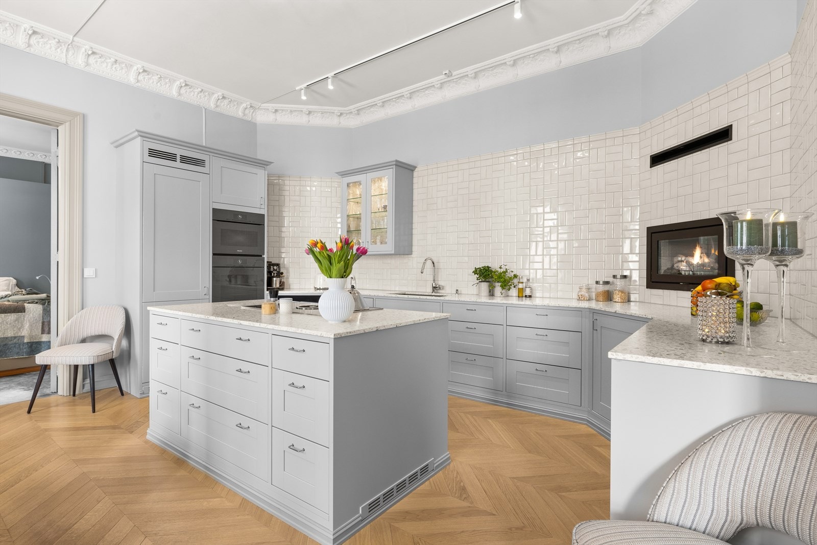 Lekkert spesialtilpasset shakerkjøkken fra Strai, med benkeplate av Terazzo marmor. Utluft fra avtrekk koketopp i sokkel på begge sider av kjøkkenøya. Galleribilde