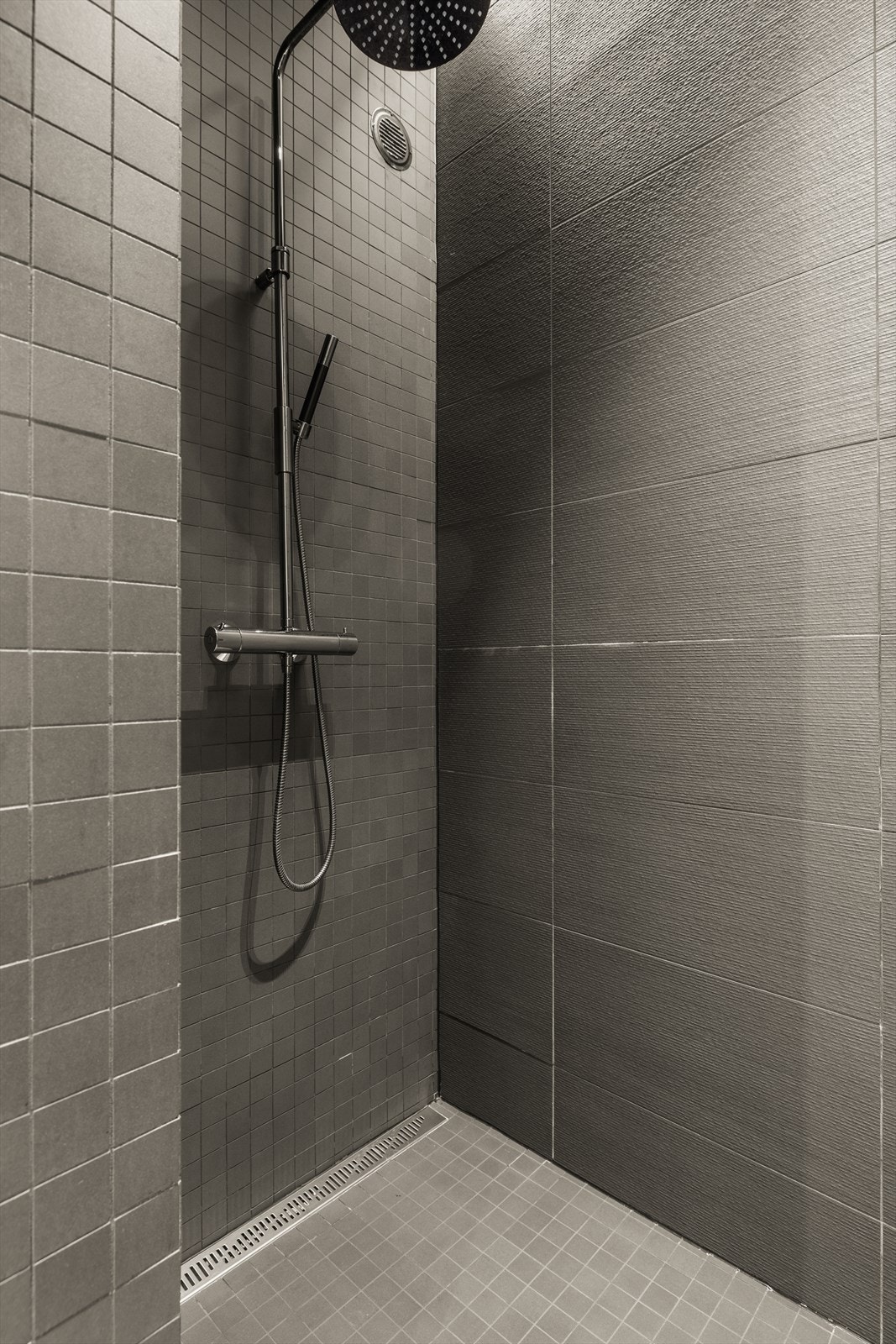 Romslig dusjsone med regndusj. LED lyslist langs vegg i dusj. Det er tapwell blandebatteri i dusj og vask. Galleribilde