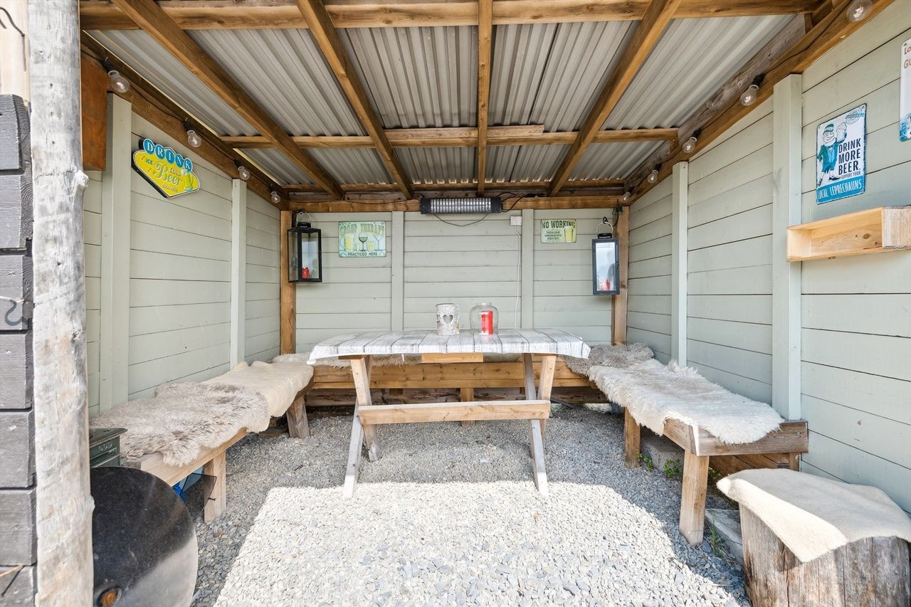 Gapahuk på tomten skaper en lun uteplass for grilling og sosiale sammenkomster i all slags vær. Galleribilde