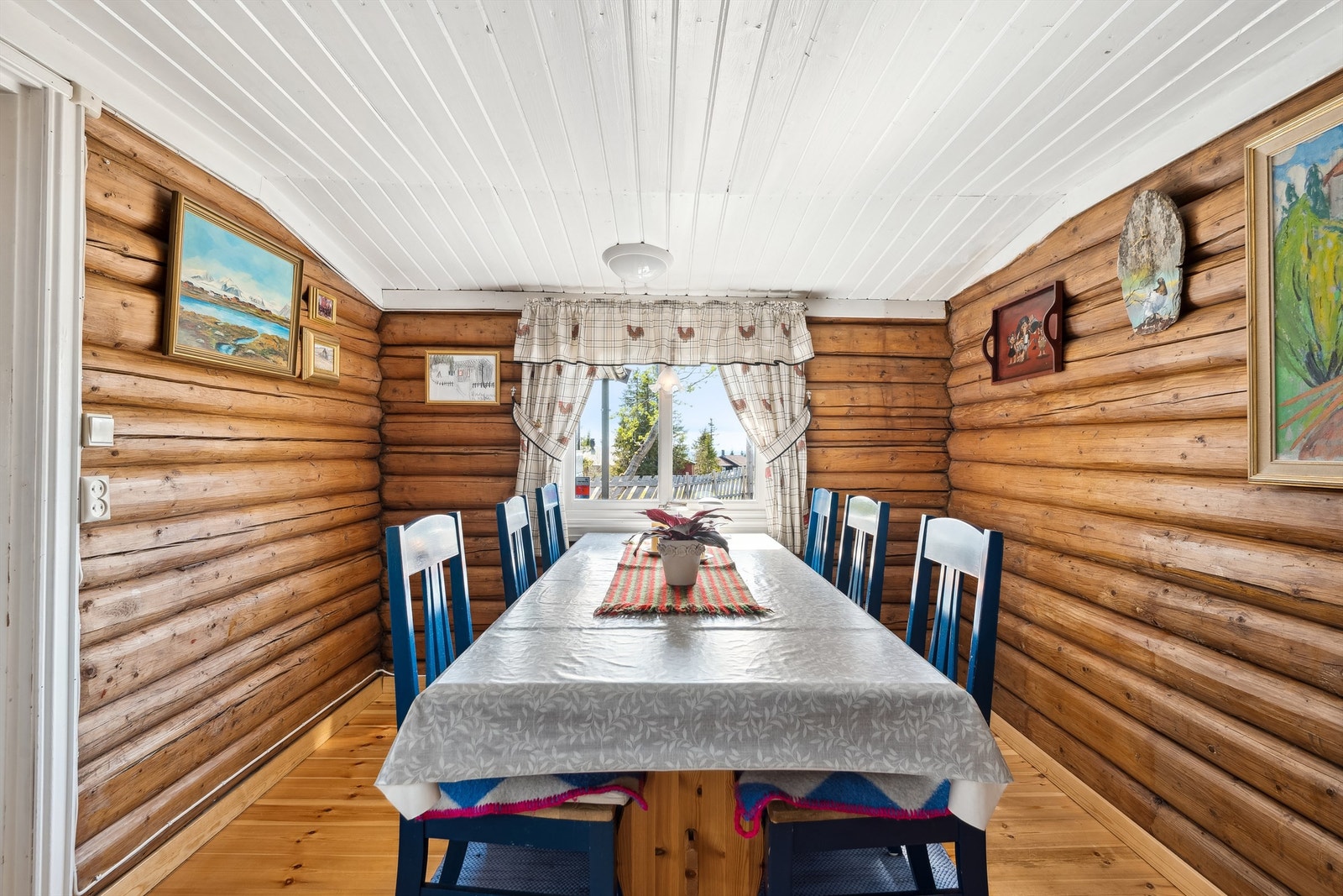 Trivelig spiseplass med tømmervegger og vindu mot uteområdet Galleribilde