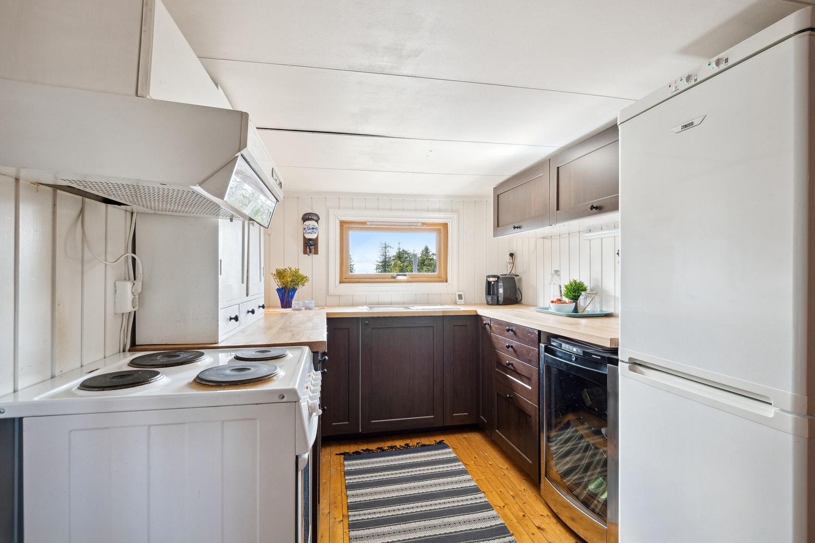 Kjøkkenet har kjøl/frys, vinskap og ventilator med avtrekk ut Galleribilde