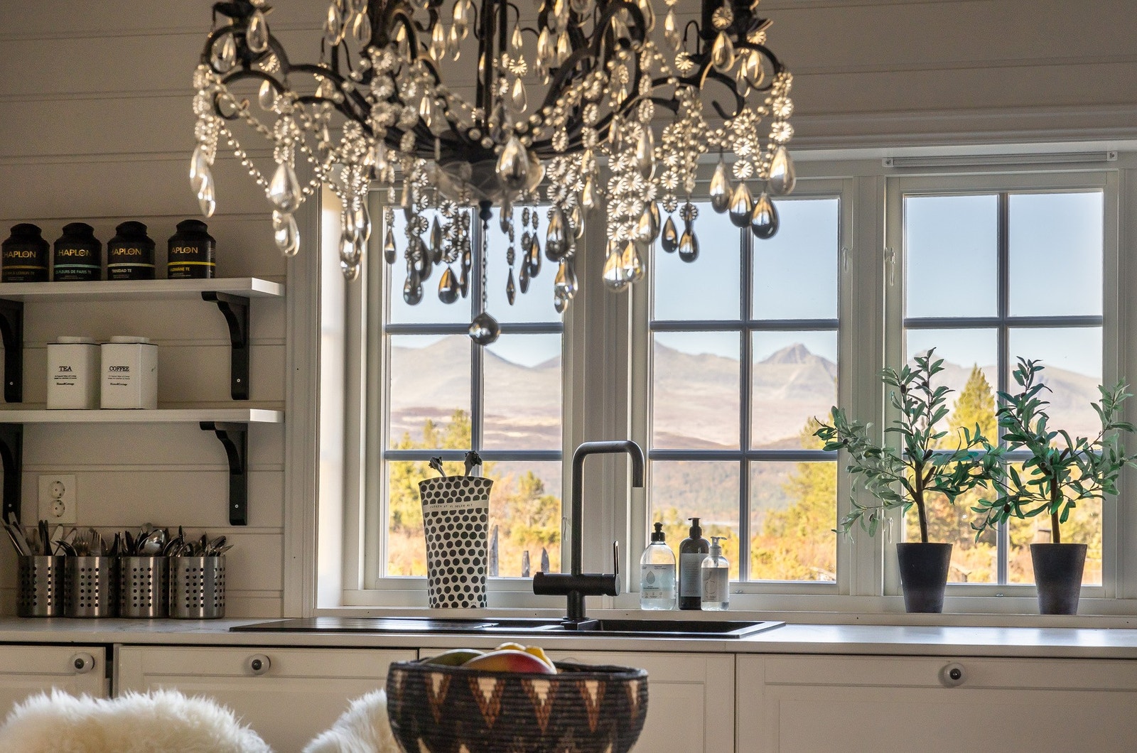 Kjøkkenet er utført i en landlig stil med profilerte fronter i hvit utførelse og benkeplate av keramisk flis. Galleribilde