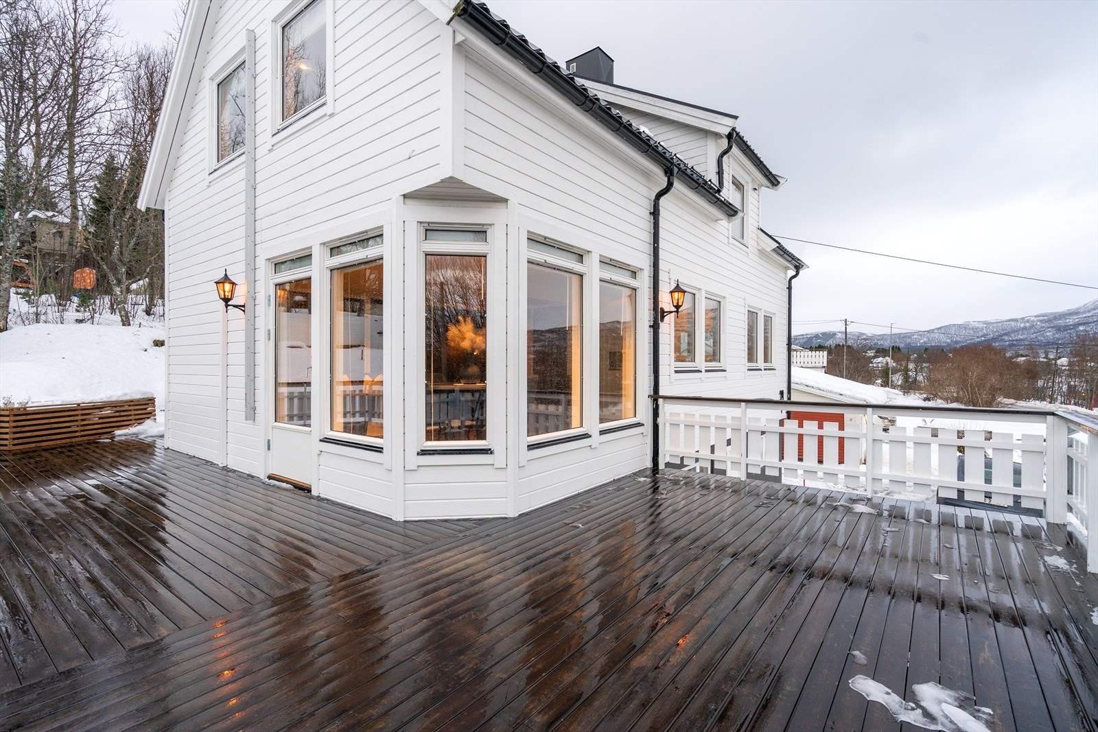 Romslig veranda med videre tilkomst til gressplen med lekestue. Galleribilde