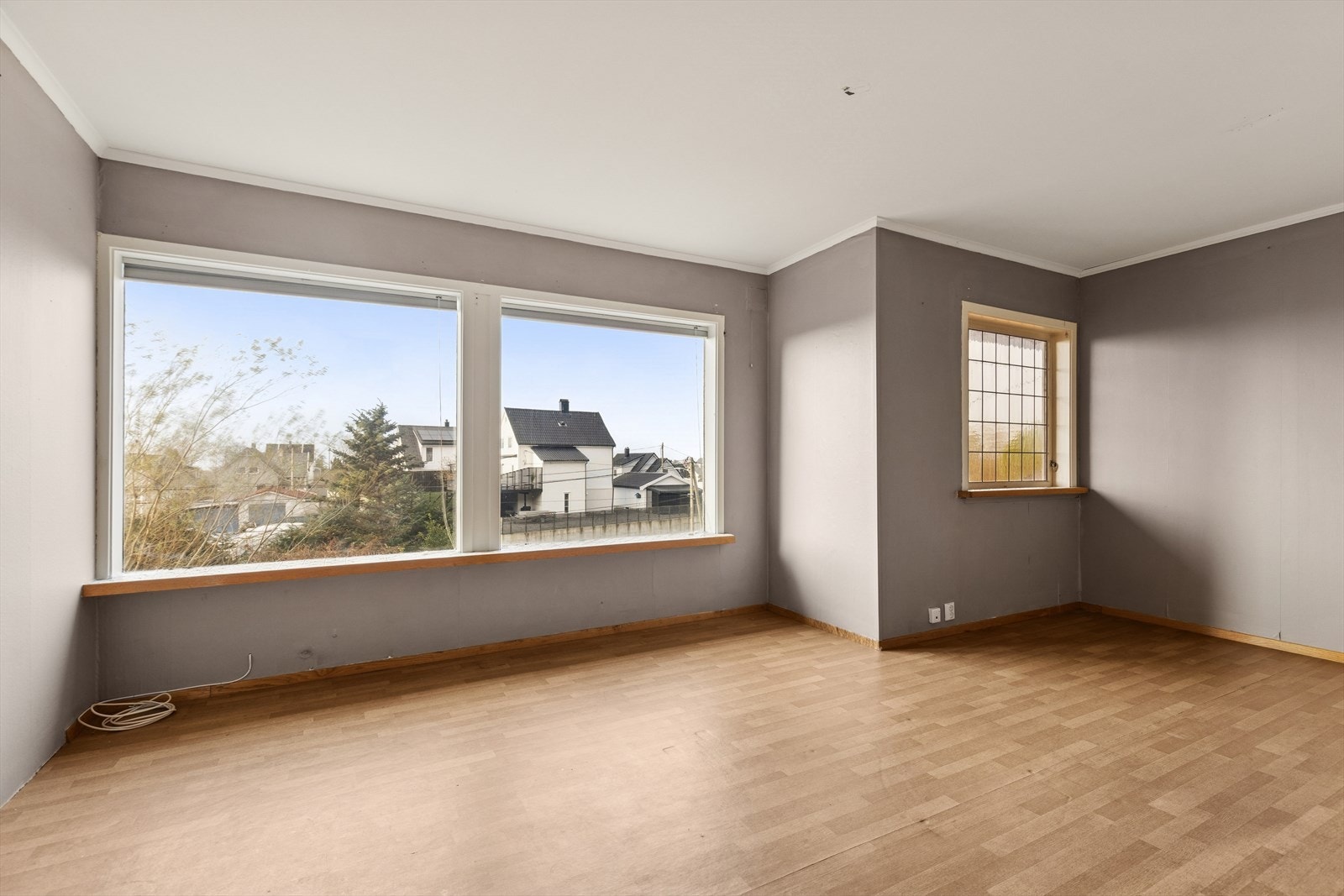 Store vindusflater i stuen i 1. etasje. Boligen har en enkel standard og krever vedlikehold. Galleribilde