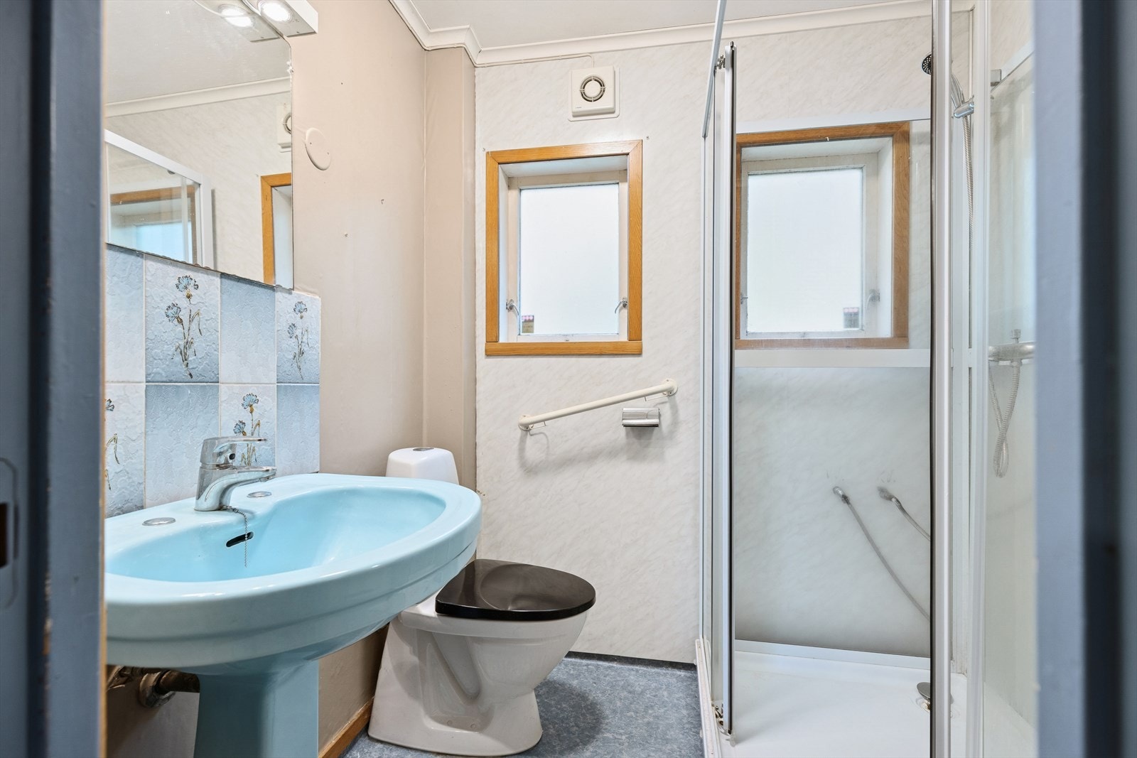 Badet er innredet med dusjkabinett, servant på vegg og gulvmontert toalett. Naturlig ventilasjon. Våtrommet må oppgraderes for å tåle normal bruk etter dagens krav. Galleribilde