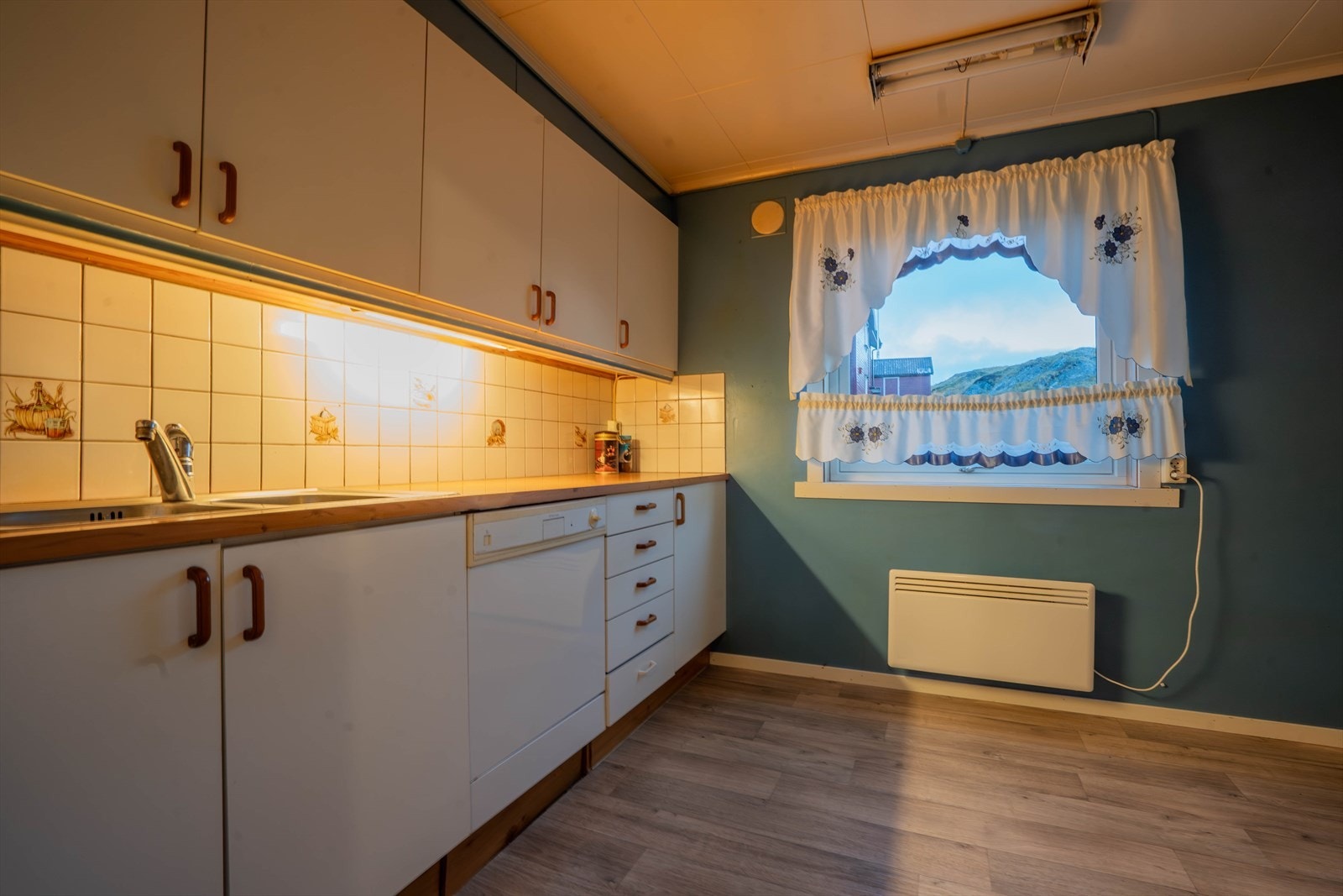 Kjøkkenet er hyggelig med stort vindu mot gata.
Godt med skap- og benkeplass. Galleribilde