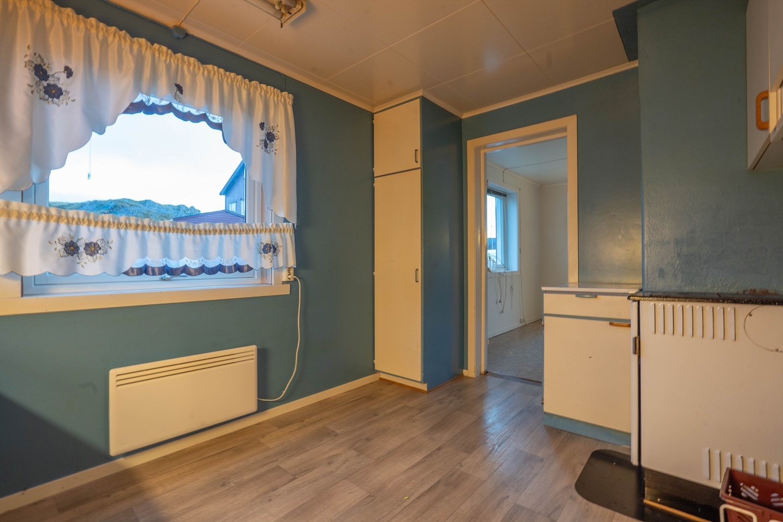 Kjøkkenet har vedovn og panelovn montert som varmekilde. Videre inn er stuen. Galleribilde