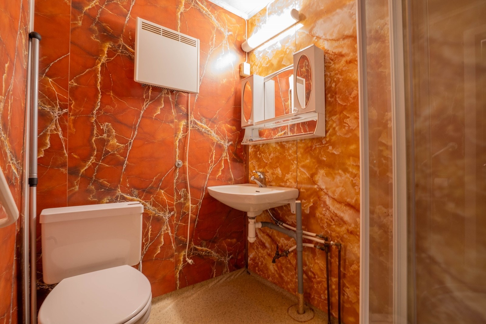 Badet i boligen kan trenge oppgradering og har i dag baderomsplater og belegg på gulv. Innredet med dusjkabinett, wc og servant. Galleribilde