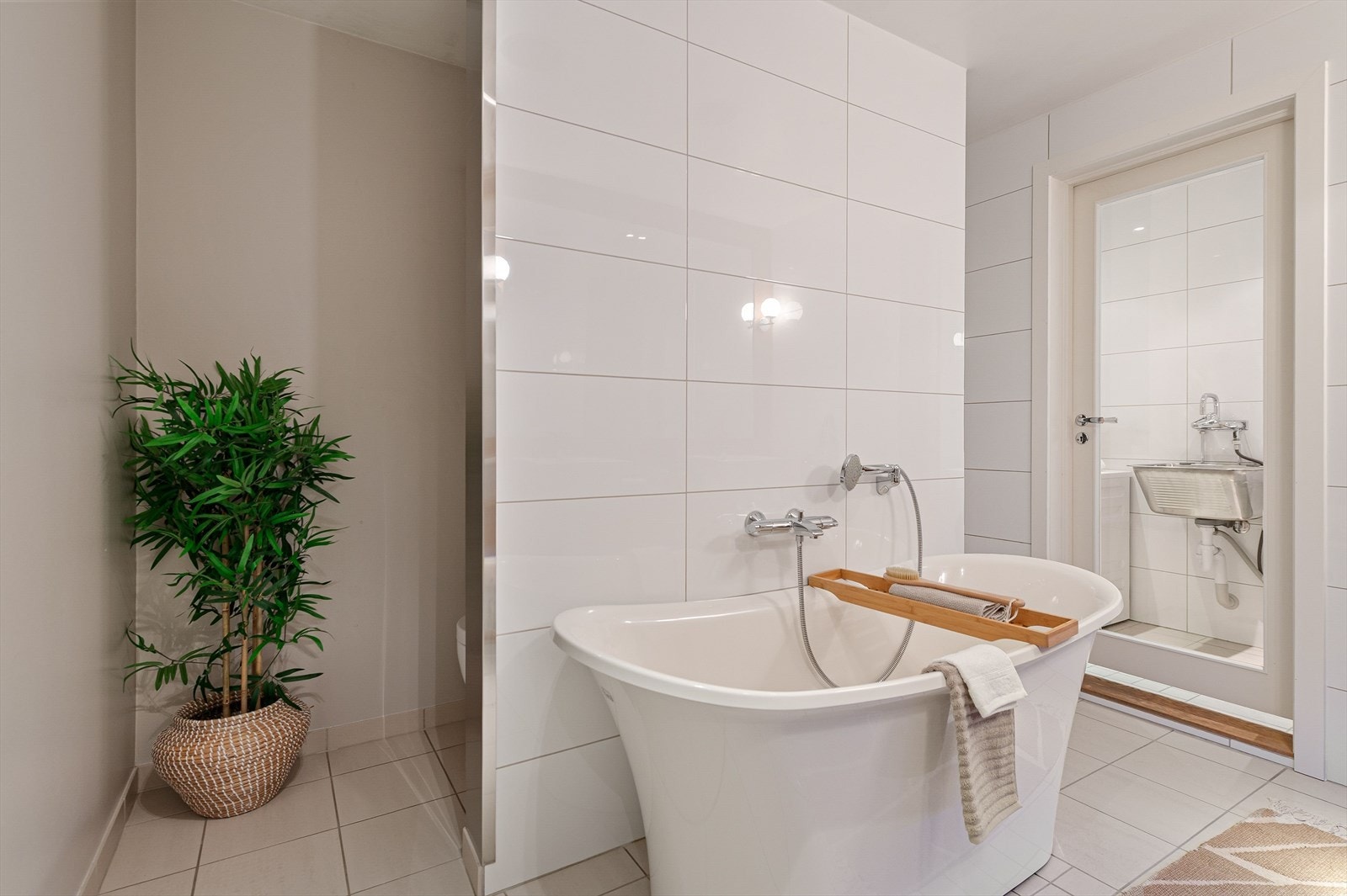 Toalett til venstre, badekar i midten og dusjnisje til høyre. Galleribilde