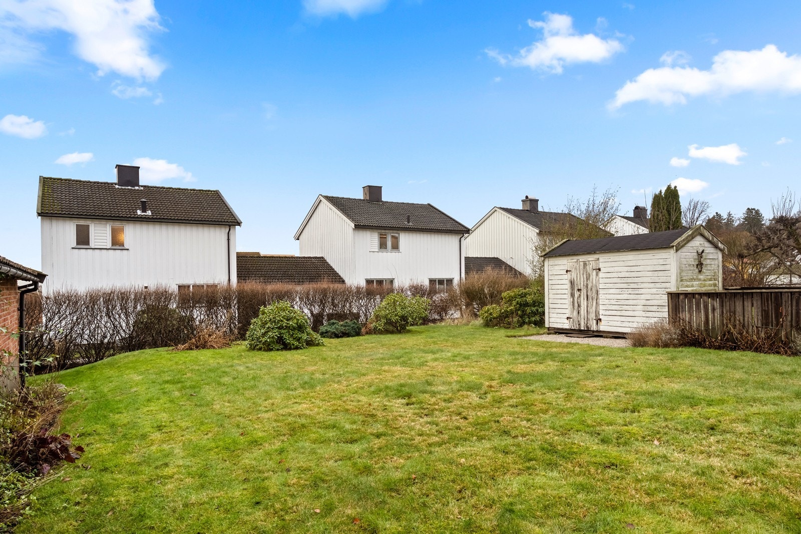 Flat opparbeidet tomt med gressplen gir gode solforhold og en romslig uteplass. Galleribilde