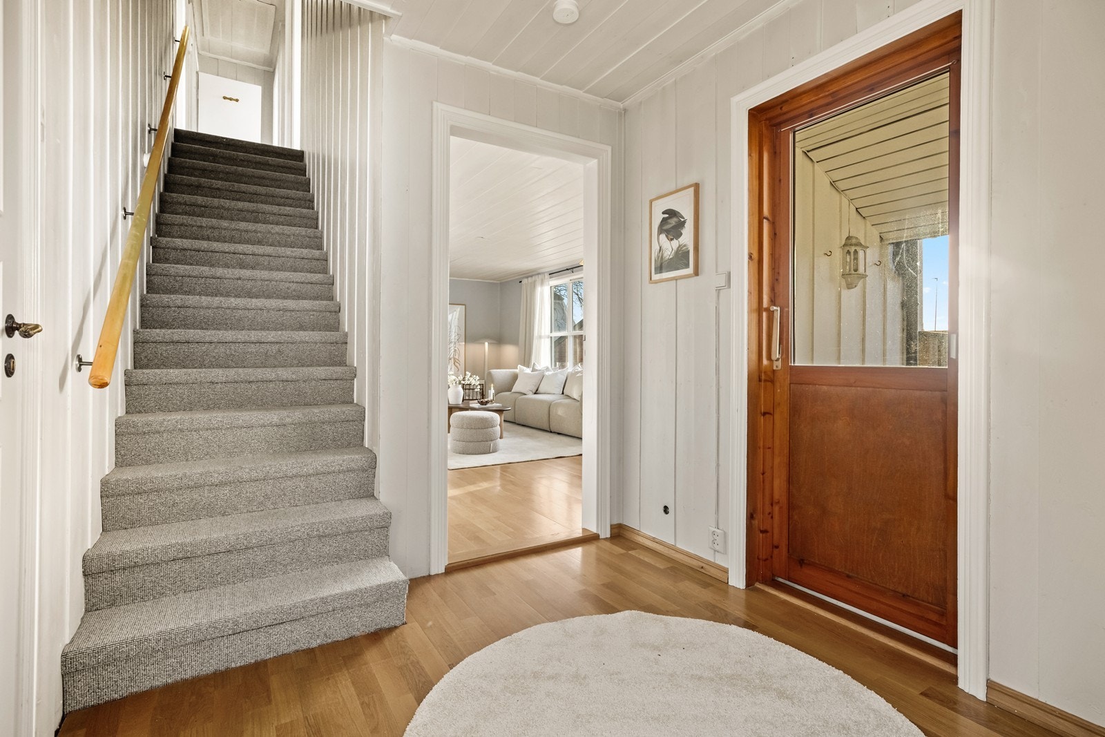Parkettgulv og en lakkert tretrapp gir et solid inntrykk i entréen. Galleribilde