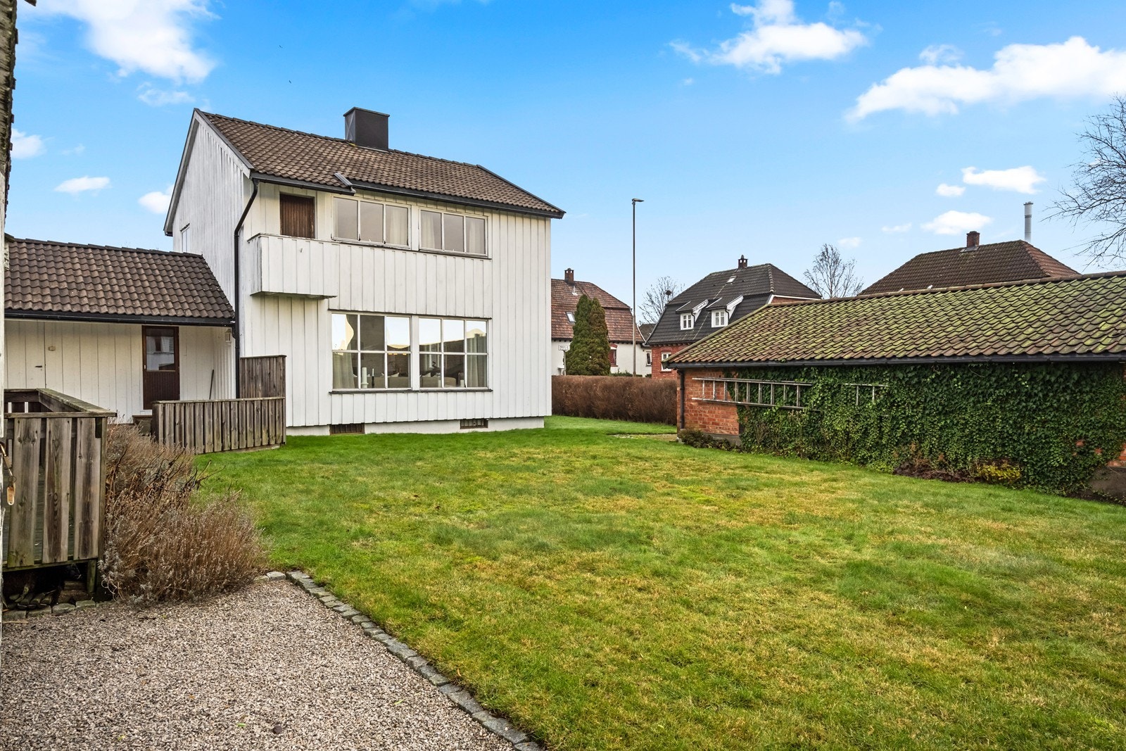 Flat opparbeidet tomt med gressplen gir gode solforhold og en romslig uteplass. Galleribilde