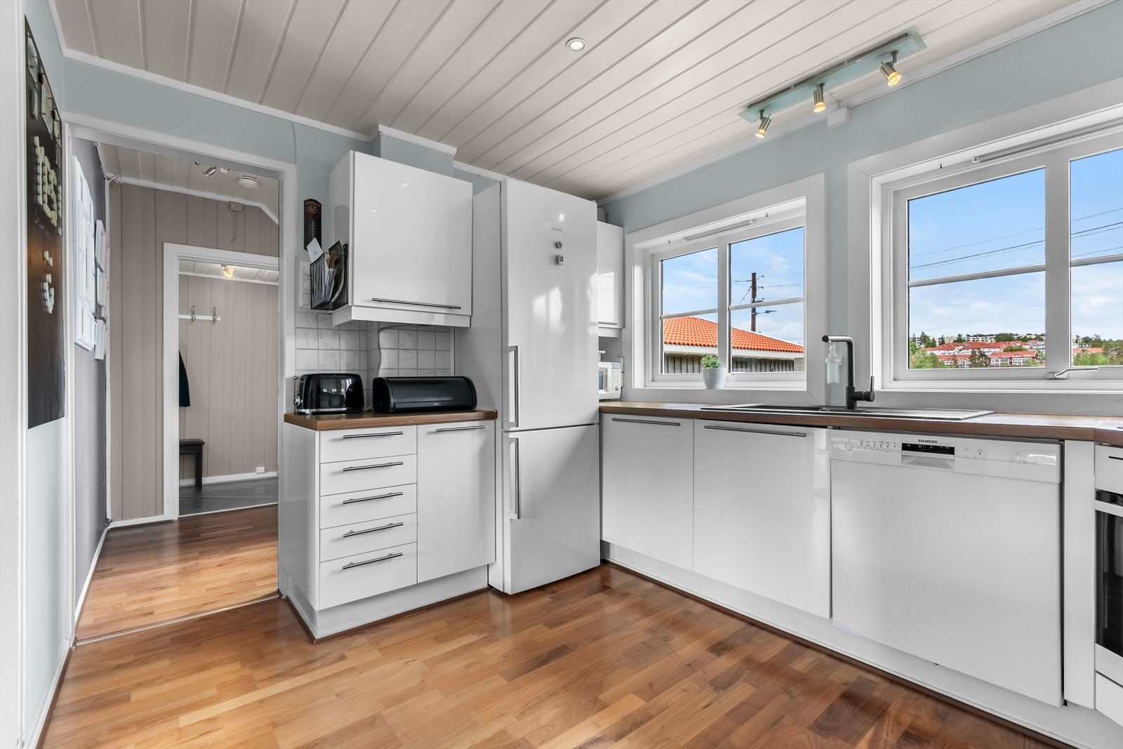 Kjøkkeninnredning med glatte, høyglans fronter og laminat benkeplate med nedfelt kum i kompositt/plast. Galleribilde