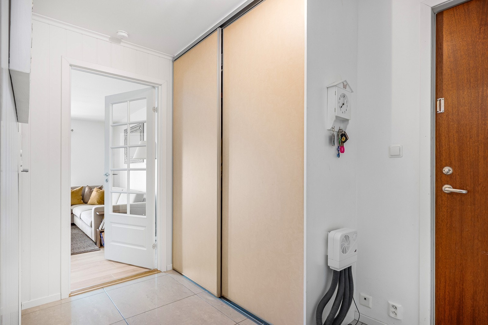 Entreen har plass til oppheng av yttertøy, en innebygd skyvedørsgarderobe sørger for orden i klær og tilbehør. Det ble lagt nye 60x60 fliser og panel i 2017. Galleribilde