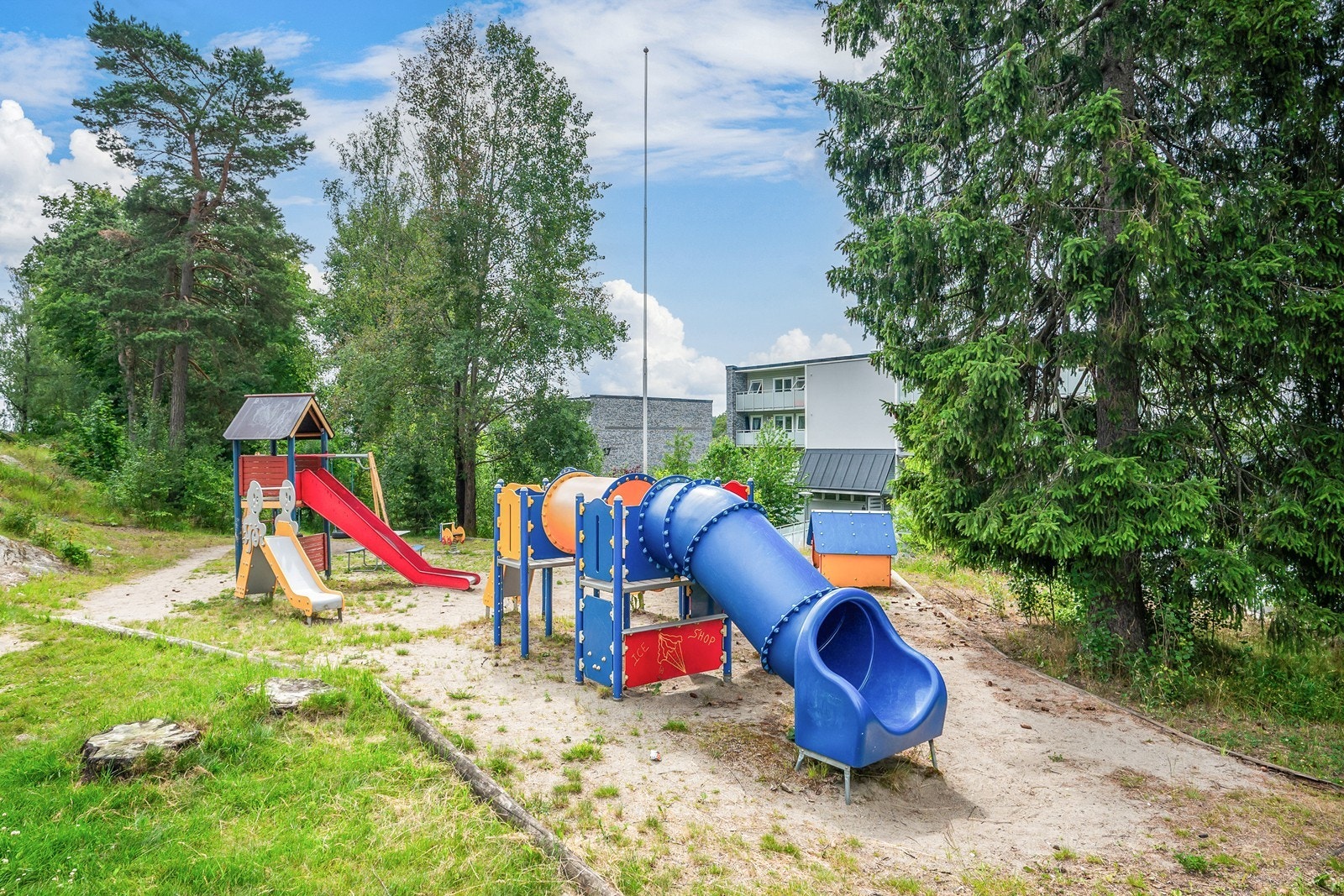 På begge sider av boligblokken er det lekeplass og sittebenker til glede for liten og stor. Galleribilde