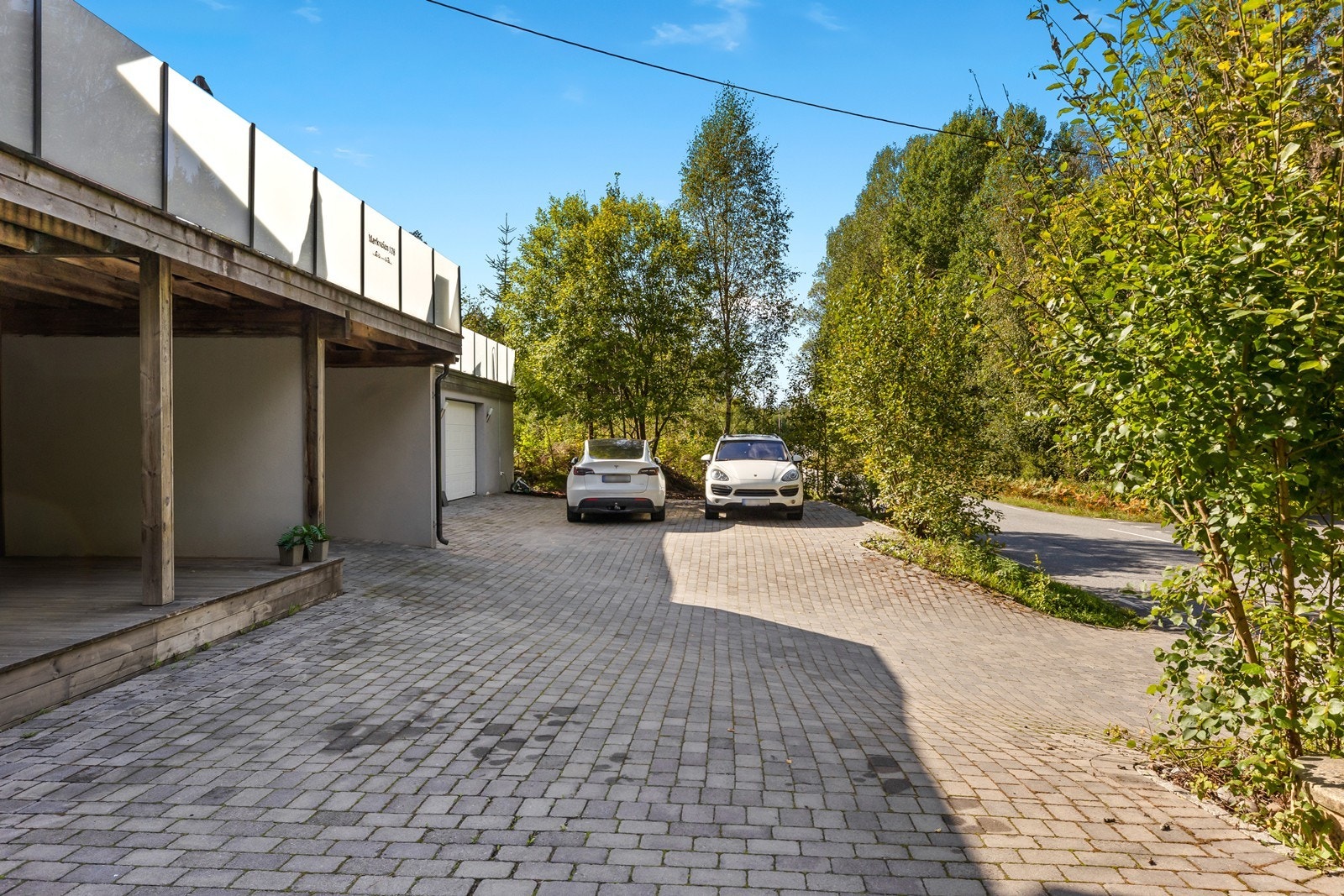 Steinlagt gårdsplass og overbygget inngang i underetasje. Galleribilde