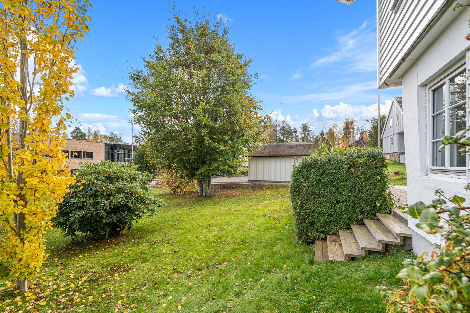 På fremsiden av huset er det trapp opp til hyggelig terrasse og inngang til boligens underetasje Galleribilde