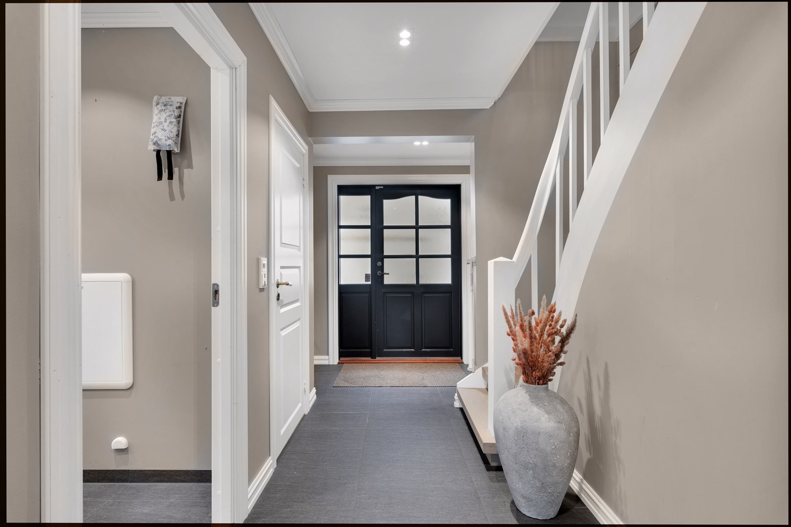 Gang malt i tidsriktige farger. Flott ytterdør som står i stil med resten av boligen. Galleribilde