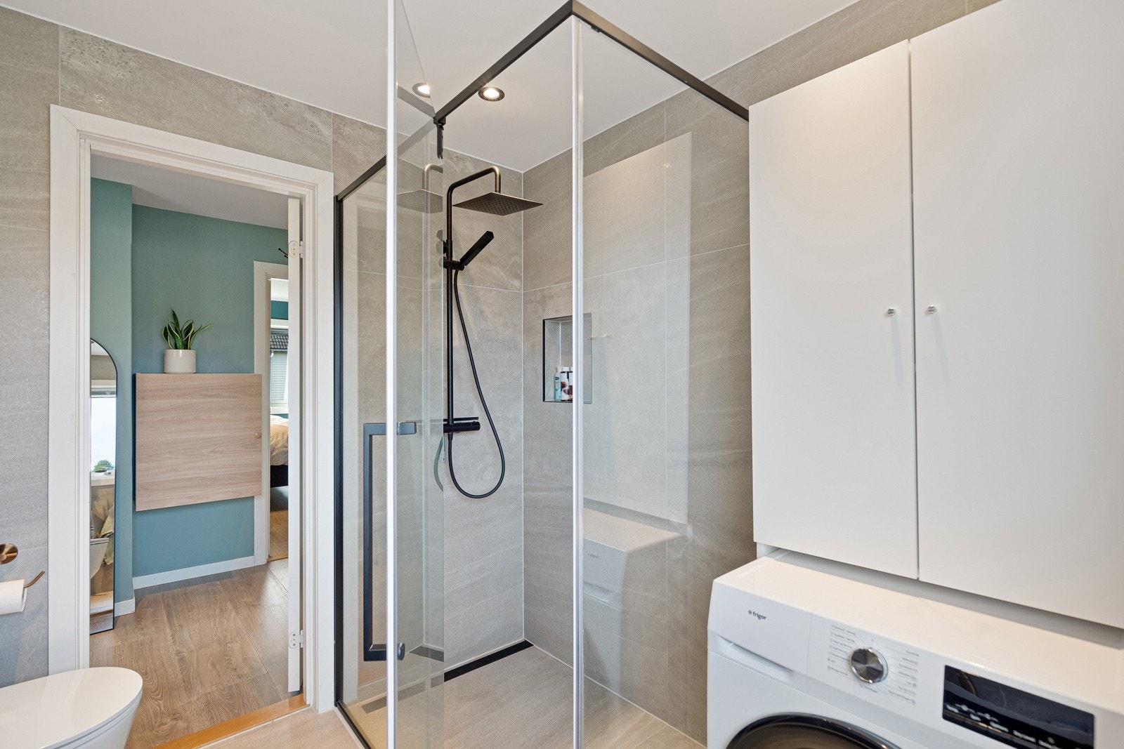 Lekkert baderom, totalt oppusset i 2022 i regi av borettslaget. Ekstra stor dusjnisje og plass til både vaskemaskin og tørketrommel Galleribilde