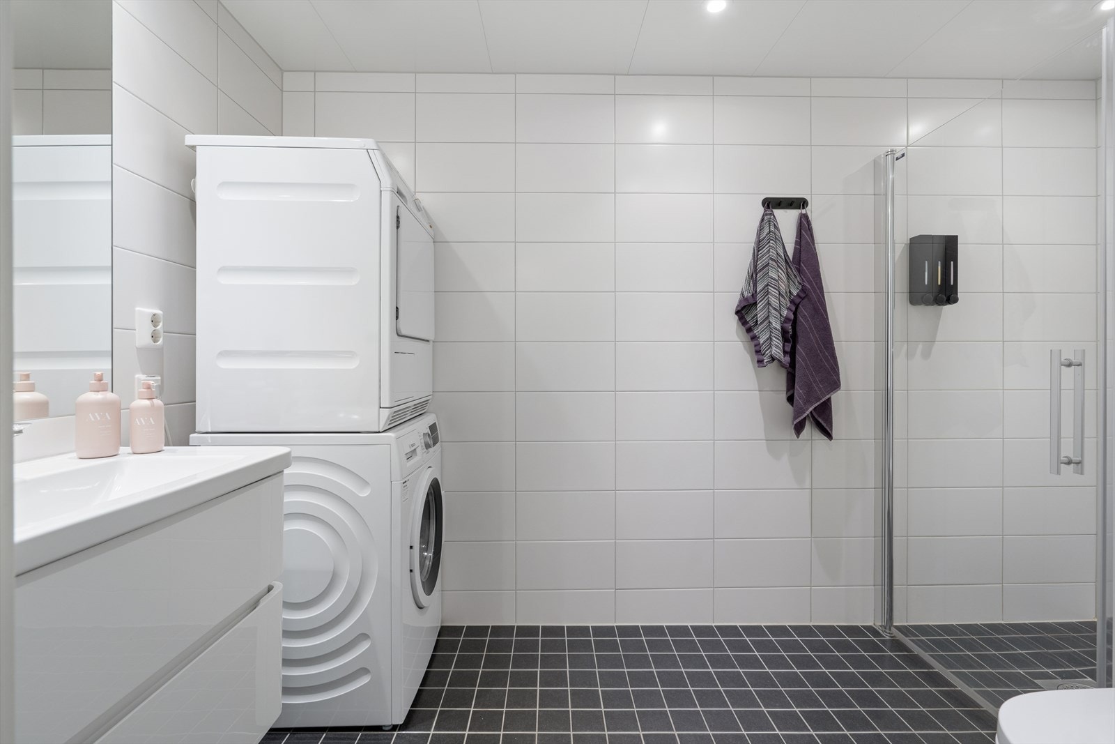 Badet i 2. etg. ligger i tilknytning til gang, og brukes som kombinert bad/vaskerom. Badet inneholder ellers moderne servantinnredning, stort speil, toalett og dusjnisje. Galleribilde
