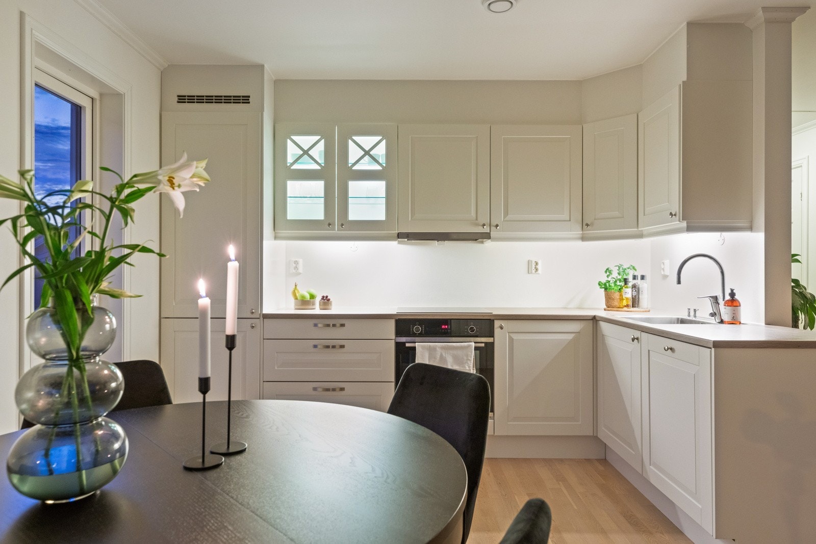 Lyst og pent kjøkken i delvis åpen løsning med stue Galleribilde