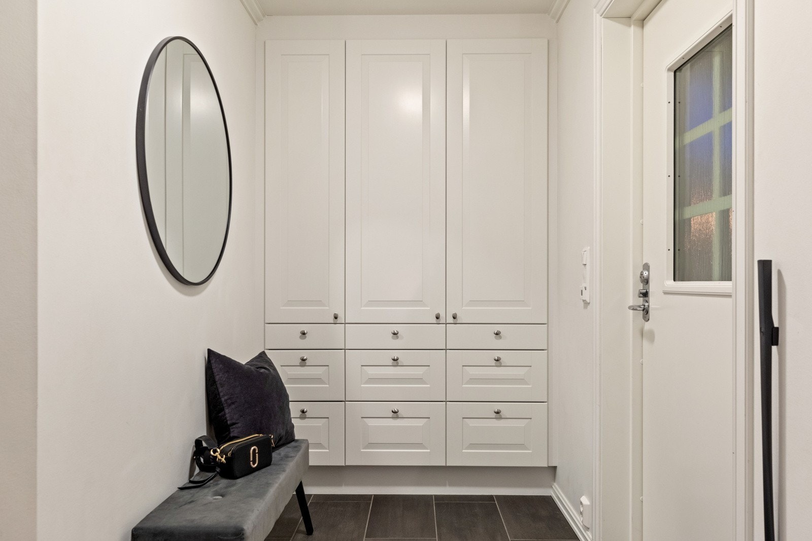 Praktisk og flislagt entrè med plassbygde garderobeskap Galleribilde