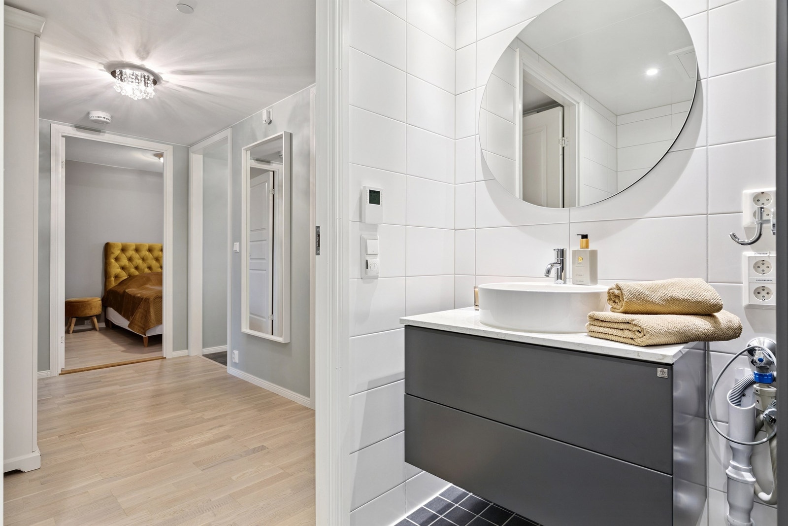 Servantskap med overliggende servant og et stort, rundt speil. Galleribilde