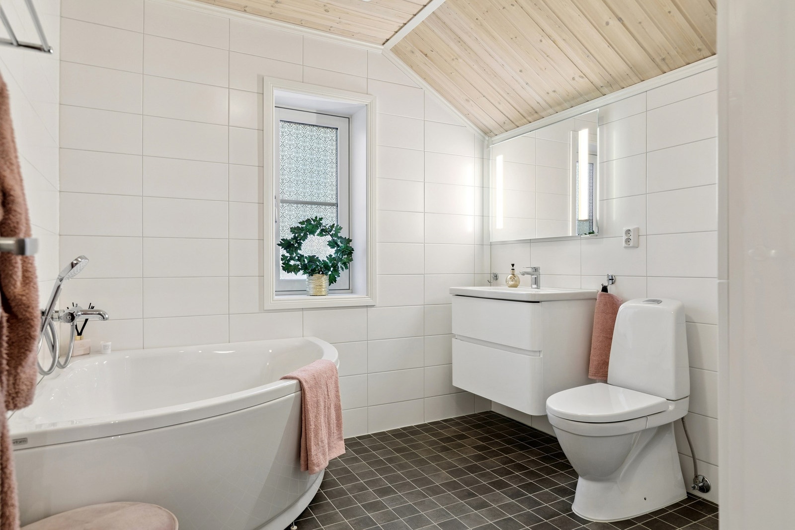 En kombinasjon av trepanel og fliser gir badet et moderne og varmt uttrykk. Galleribilde